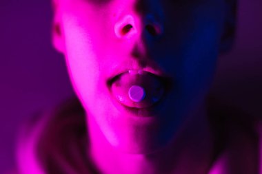 Pembe kapüşonlu genç hap kullanıyor. LSD tekerli dilli adam.