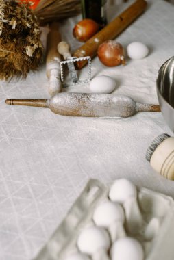 Hamur tatlısı modelliği ya da pişirme hazırlığı. Un, merdane ve yumurta dolu bir masa.