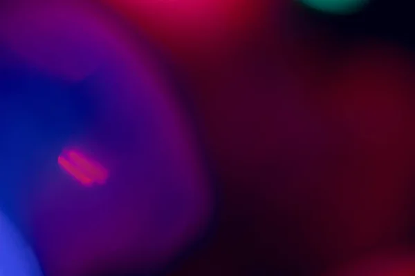 abstract lens flare on black background. blue, red, purple, pink defocused bokeh lights. glowing color burst. bokeh abstract backdrop