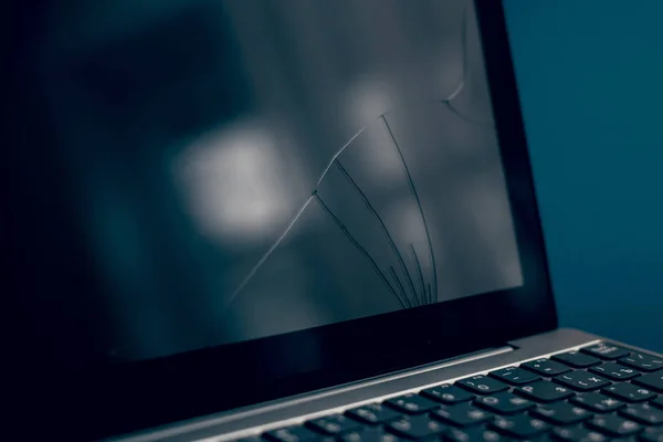 Laptop się popękał i został uszkodzony. Srebrny laptop z zepsutym tabletem z popękanym wyświetlaczem. Zbliżenie obraz części zepsutego laptopa i pęknięty ekran na klasycznym niebieskim tle — Zdjęcie stockowe