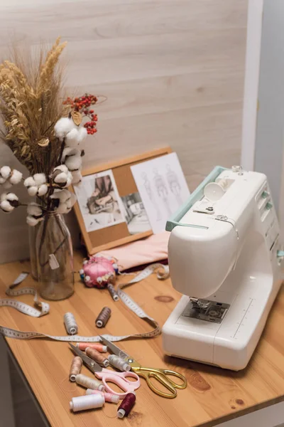 Робоче місце швачки. Швейна машина на столі, нитках, ножицях — стокове фото