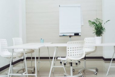 Sandalyeleri, masası ve çizelgesi olan küçük, parlak, boş bir ofis. Üniversitede okumak için küçük rahat bir oda. Kopyalama alanı, şablon