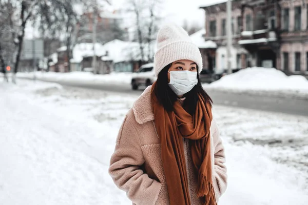 Uma mulher na rua no inverno protege o trato respiratório da epidemia de coronavírus. Proteção contra nevoeiro urbano e poeira — Fotografia de Stock