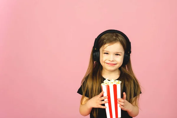 Niña Con Auriculares Grandes Una Película Come Maíz Pop Sonríe — Foto de Stock