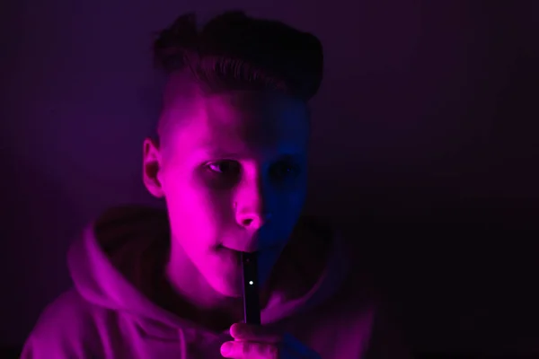 Young Guy Smokes Electronic Cigarette Neon Light Teenage Boy Soars — Stock Photo, Image