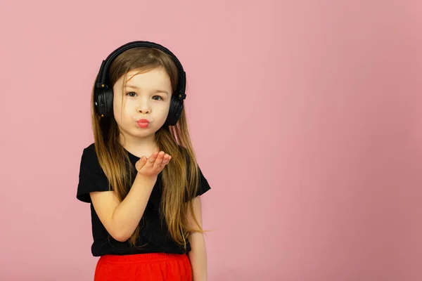 Una Niña Escucha Música Con Auriculares Grandes Sobre Fondo Rosado — Foto de Stock