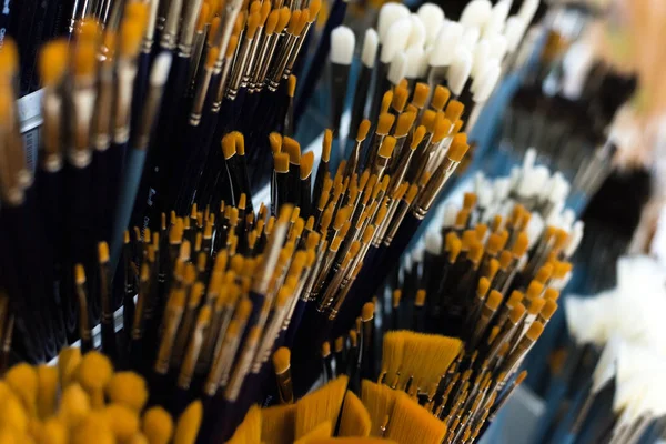 Group of artistic paintbrushes for artist. New paint brushes on shelf display in stationery shop. Art painting concept. The concept of selling tools for artists, the choice of brushes.