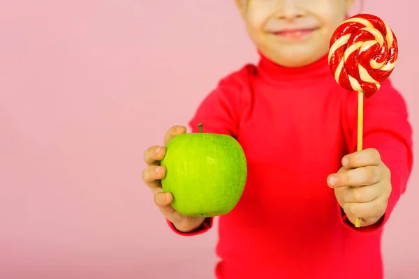Κοριτσάκι Διαλέγει Ανάμεσα Ένα Γλειφιτζούρι Και Ένα Πράσινο Μήλο Έννοια — Φωτογραφία Αρχείου