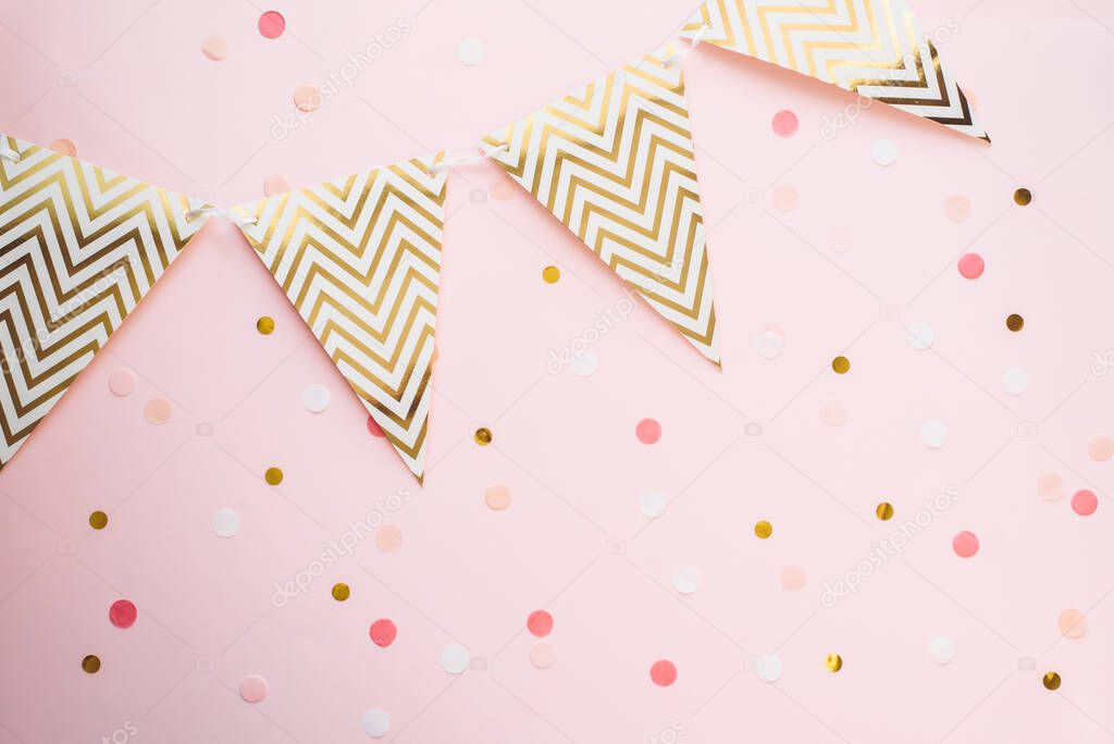 Template for the holidays. Paper garland of flags on a pink background with confetti.
