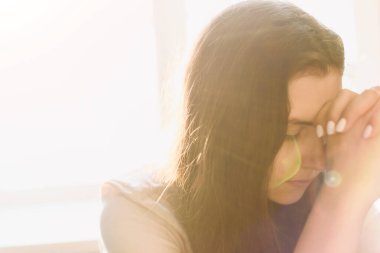 Sevimli güzel kız dua ederken ellerini kavuşturdu. Bir kadın Tanrı 'dan yardım ister..