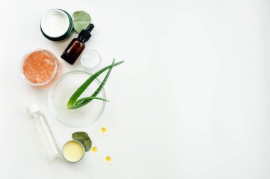 Aloe beyaz bir masaya nemlendirici krem, maske ve tonik bırakır. Evde doğal makyaj ürünleri yaratmak. Doğal özleri karıştırarak anti-yaşlanma serumu üretiliyor..