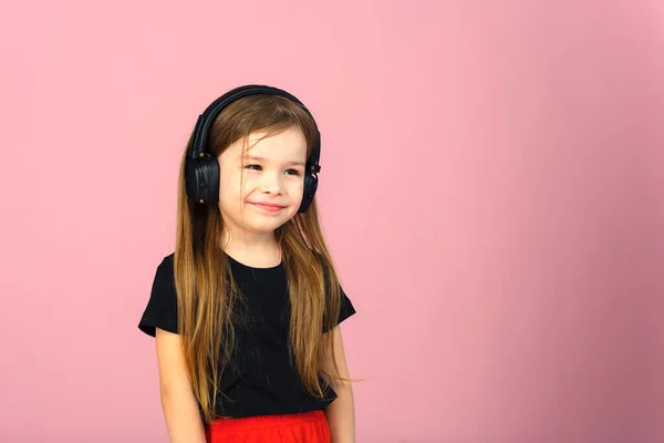 Una Niña Pequeña Con Auriculares Negros Grandes Inalámbricos Sobre Fondo — Foto de Stock