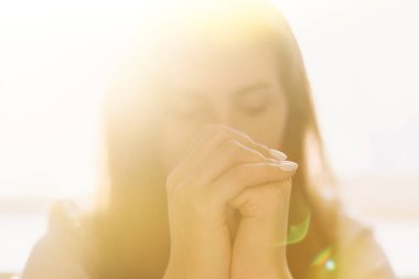 Sevimli güzel kız dua ederken ellerini kavuşturdu. Bir kadın Tanrı 'dan yardım ister..