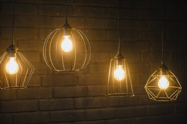 Göz kamaştırıcı bir lambanın yakın çekimi. Turuncu ışıklı ampul. Büyük bir dekoratif spiral ile parlak bir edison lamba yakmak..