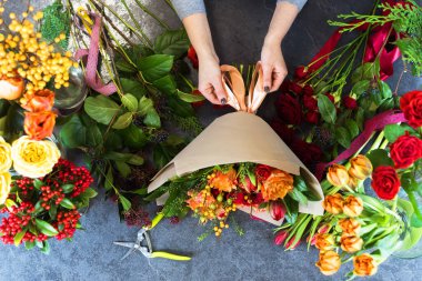 Güzel bir buket kırmızı, turuncu, bordo, sarı güller, laleler. Yukarıdan bak. Düz konum.