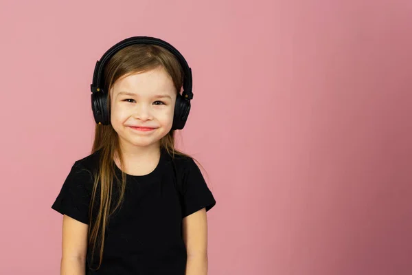 Una Niña Pequeña Con Auriculares Negros Grandes Inalámbricos Sobre Fondo — Foto de Stock