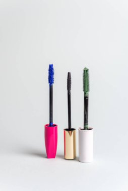 Various mascara brushes on a blue pastel background. The concept of choosing makeup products.