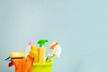 Temizlik için cephanelik gri arka planda. Bir evde temizlik yapmak. Temizle ve yıka. Kovadaki temizlik malzemesi.