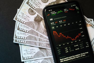 Samara Rusya - 04.05.2020: iPhone 11 ekranındaki General Electric Corporation yüz dolarlık banknotlara karşı. Hisse senetlerinin düşüşü ve büyümesi, komisyon hesabı konsepti, kar payı ve karı.