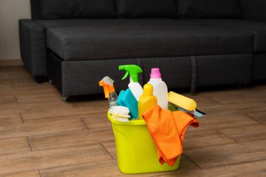 Yerde deterjanı olan sarı bir kova. Temizlik malzemeleri kovada..