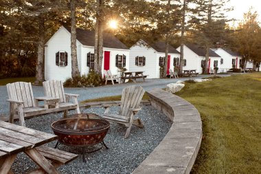 Trenton, Maine - 27 Eylül 2019: Open HEarth Inn Oteli 'ndeki kır evleri gün batımında yemyeşil yapraklarla çevrili. 