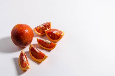 Tüm kırmızı turuncu beyaz arka planda yatıyor. Yakınlarda portakal dilimleri var. İzole et