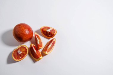 Tüm kırmızı turuncu beyaz arka planda yatıyor. Yakınlarda portakal dilimleri var. İzole et