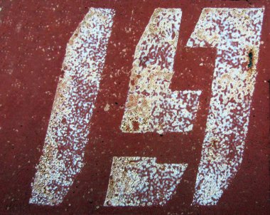 Paslanmış kırmızı kahverengi metal yüzey üzerine 19 numara beyaz numara boyanmış.