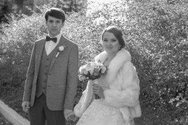 Güzel çalıların arasında el ele tutuşan evli bir çift.