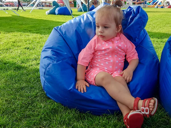 Parktaki renkli koltuklarda oynayan sevimli çocuk. — Stok fotoğraf