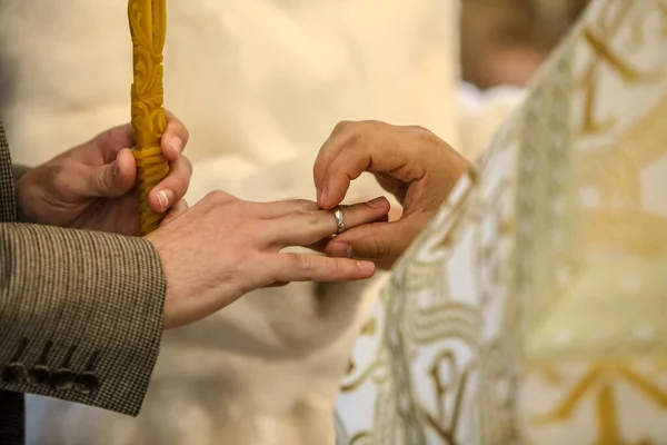 Священник надевает обручальное кольцо на палец жениха . — стоковое фото