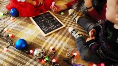 Anne ve kızı tahtaya yeni yıl özelliklerini çiziyor. Anne ve kızı bir Noel ağacı çiziyorlar. Yeni yıl teması: anne ve kızı yeni yılı evde şenlikli bir ortamda resmediyorlar..