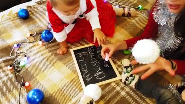妈妈和女儿在黑板上画新年标志 妈妈和女儿正在画一棵圣诞树 新年主题 母女俩在家庭喜庆的气氛中粉刷新年 — 图库视频影像