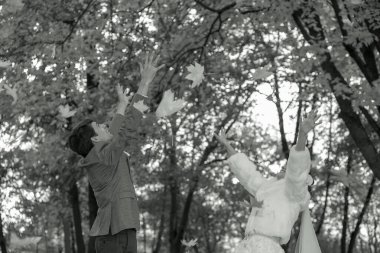 Gelin ve damat sonbahar parkına yapraklar atıyor.