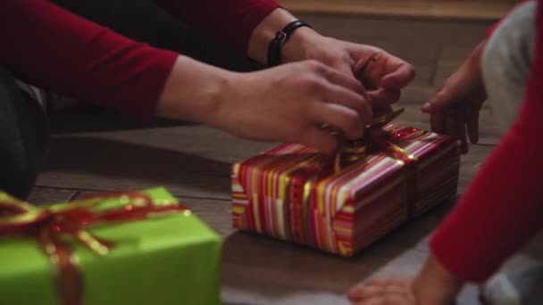 Primer plano de las manos de mujer y niña embalaje regalos en cajas en colores de Navidad y Año Nuevo . — Vídeos de Stock