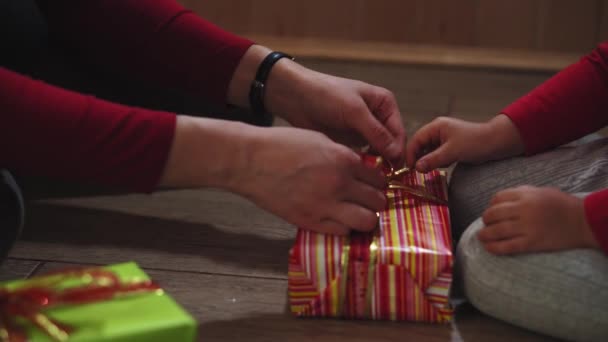 Nahaufnahme von Frauen- und Mädchenhänden beim Verpacken von Geschenken in Schachteln in Weihnachts- und Neujahrsfarben. — Stockvideo