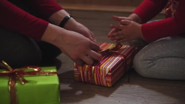 Zbliżenie kobiety i dziewczyny ręce pakowanie prezentów w pudełkach w Boże Narodzenie i Nowy Rok kolory. — Wideo stockowe