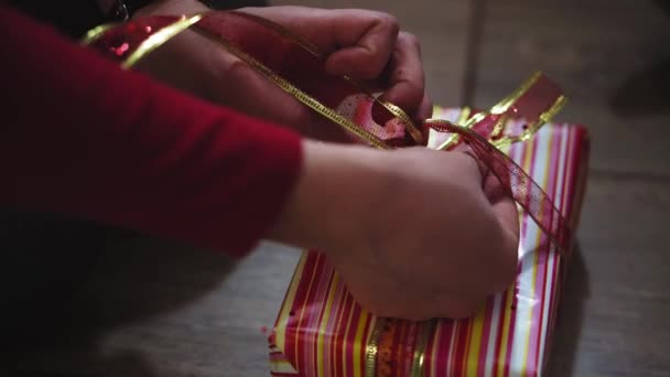 Primer plano de las manos de mujer y niña embalaje regalos en cajas en colores de Navidad y Año Nuevo . — Vídeo de stock