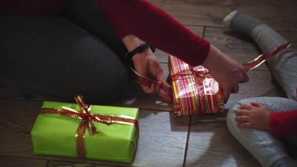 Крупный план женских и женских рук, упаковывающих подарки в коробки в рождественских и новогодних цветах . — стоковое видео
