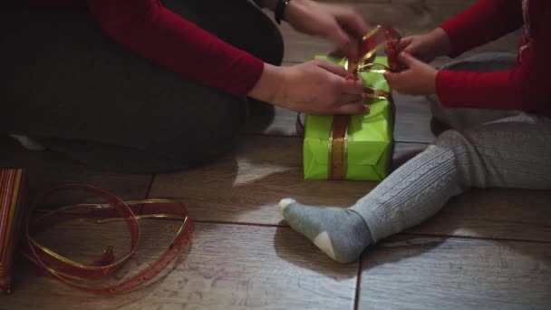 Крупный план женских и женских рук, упаковывающих подарки в коробки в рождественских и новогодних цветах . — стоковое видео