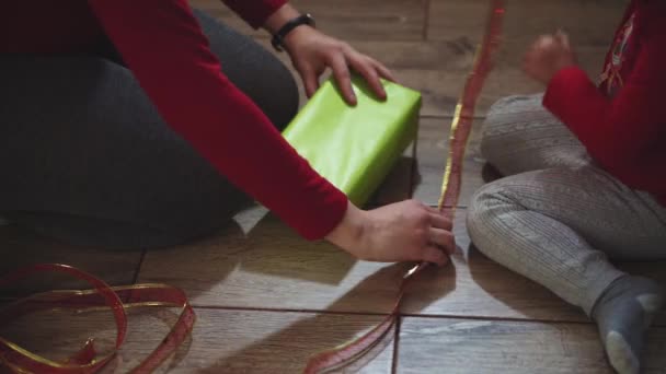 Nahaufnahme von Frauen- und Mädchenhänden beim Verpacken von Geschenken in Schachteln in Weihnachts- und Neujahrsfarben. — Stockvideo