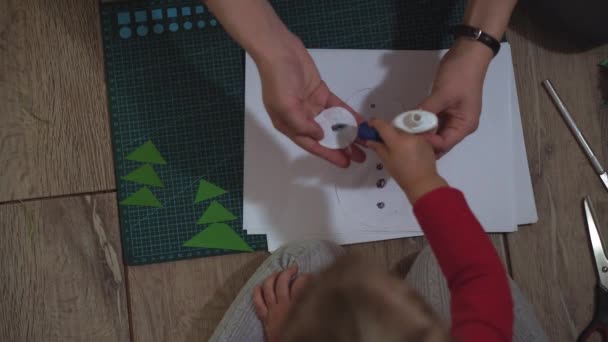 Close up of woman and little girl hands making snowman with paper applique. — Stock Video