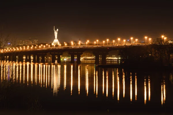 Vista noturna da ponte sobre o amplo rio Dnipro em Kiev em uma longa exposição — Fotografia de Stock