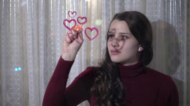 Bella ragazza dipinge un cuore su vetro — Video Stock