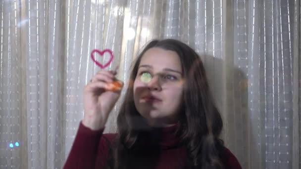 Beautiful girl paints a heart on glass — ストック動画