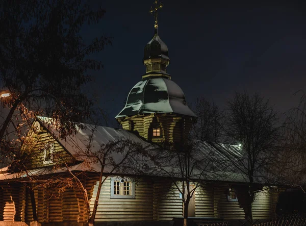 Árvore ortodoxa Igreja russa coberta de neve. Igreja de madeira com luzes e cruzes iluminadas em topos na véspera de Natal. Noite de Natal perto da igreja cristã, momento espiritual . — Fotografia de Stock