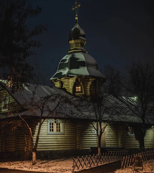 Árvore ortodoxa Igreja russa coberta de neve. Igreja de madeira com luzes e cruzes iluminadas em topos na véspera de Natal. Noite de Natal perto da igreja cristã, momento espiritual . — Fotografia de Stock