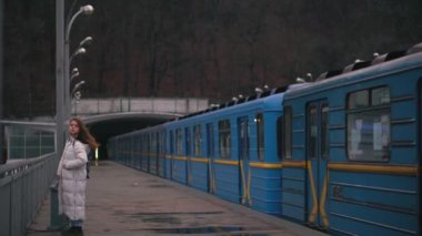 Mavi metro treni Kiev 'deki geniş Dinyeper Nehri' nin karşısındaki köprüdeki yer istasyonundan ayrılıyor..