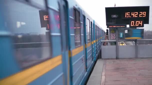 Il treno blu della metropolitana lascia la stazione a terra sul ponte che attraversa l'ampio fiume Dnieper a Kiev. Due treni blu della metropolitana divergono in una stazione a terra su un ponte attraverso il fiume Dnieper a Kiev — Video Stock