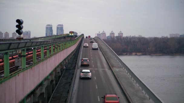 Der blaue U-Bahn-Zug kommt an der Bodenstation auf der Brücke über den breiten Dnjepr in Kiev an. — Stockvideo